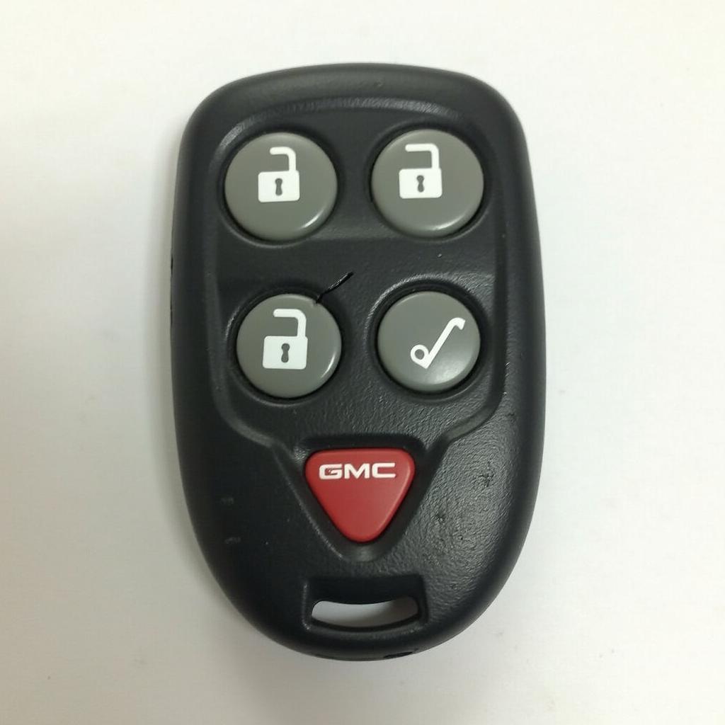 2002 GMC Yukon key fob malfunctioning: a close-up of a worn-out key fob with unresponsive buttons and a cracked casing, demonstrating common issues.