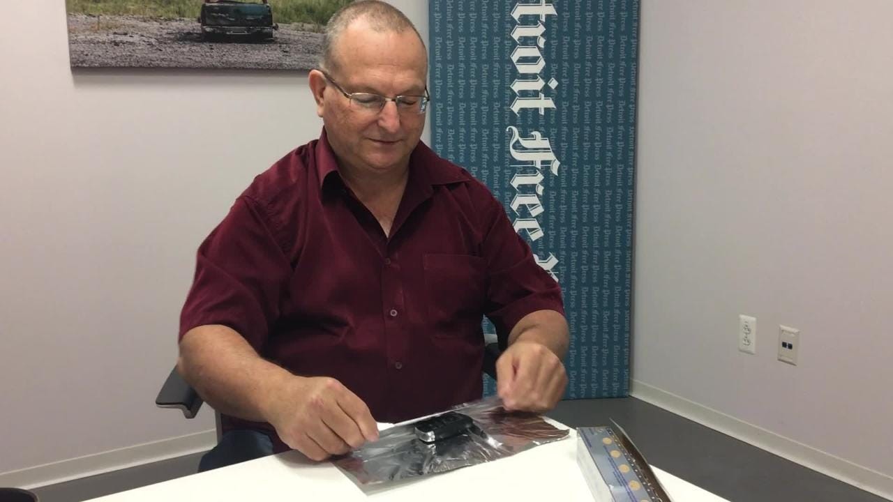 Man holding a metal coffee can, suggesting it as a Faraday cage to block key fob signals and prevent relay attacks by thieves.