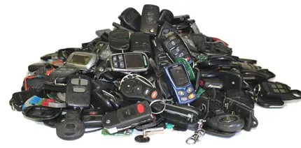 A pile of used car key fobs collected from auto recycling, showcasing the potential for recycling and reuse.