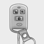 Opening the 2011 Hyundai Elantra key fob casing with a flathead screwdriver for battery replacement.