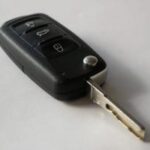 Modern car key fob featuring buttons for remote vehicle access, contrasted with a traditional metal car key.