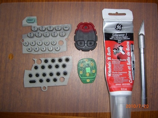 Disassembled key fob remote with tools and materials