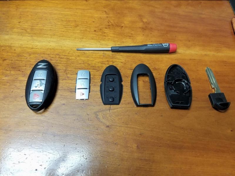 Parts for Nissan 370z key fob shell replacement including new shell and old worn key fob