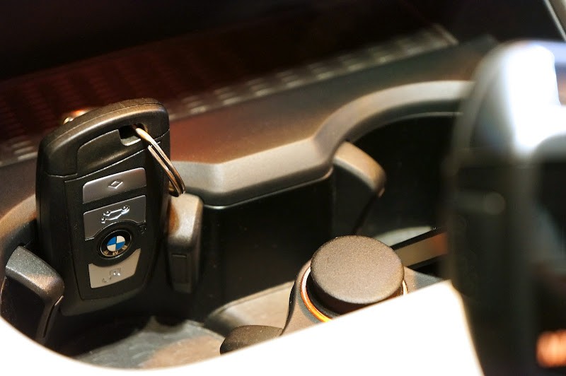 BMW F25 cup holder ingeniously used as a key fob holder, showcasing a simple car hack for keyless entry systems.