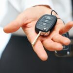 Modern car factory key fob with lock, unlock, trunk, and remote start buttons highlighted.