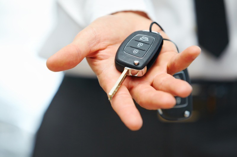 Modern car factory key fob with lock, unlock, trunk, and remote start buttons highlighted.