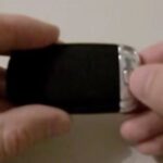 Press the release button on the back of the Audi key fob to remove the emergency key.