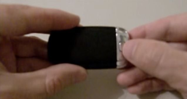 Press the release button on the back of the Audi key fob to remove the emergency key.