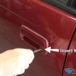 Inserting car key into door lock to manually lock the vehicle, a step in resetting the security system.