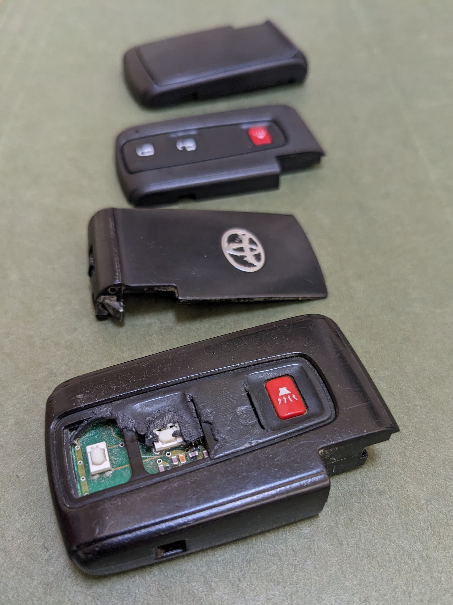 Comparison of an old, worn Toyota key fob next to a new aftermarket replacement shell, highlighting the improvement achievable through DIY repair.