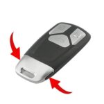 Pressing black buttons on Audi TT key fob to release the physical key.