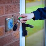 Close-up of a person tapping a key fob on a reader to enter an apartment building